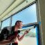 One of the members of the AP Corp team working on a security window film installation in a school.
