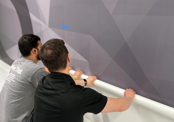 Solar Tint team installing custom wayfinding wall graphics.