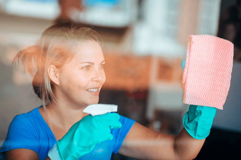 woman cleaning window film