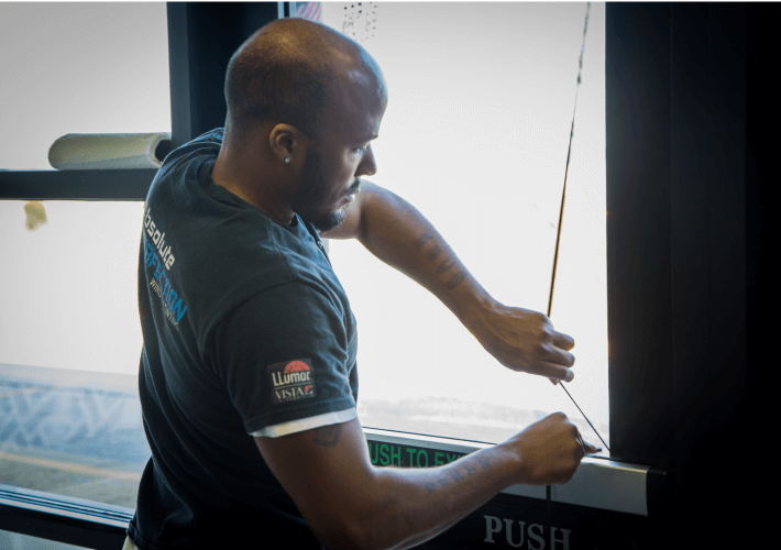 man installing security window film