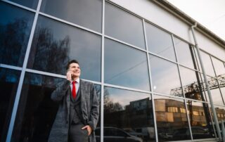 A man standing in front of commercial windows covered with security film.