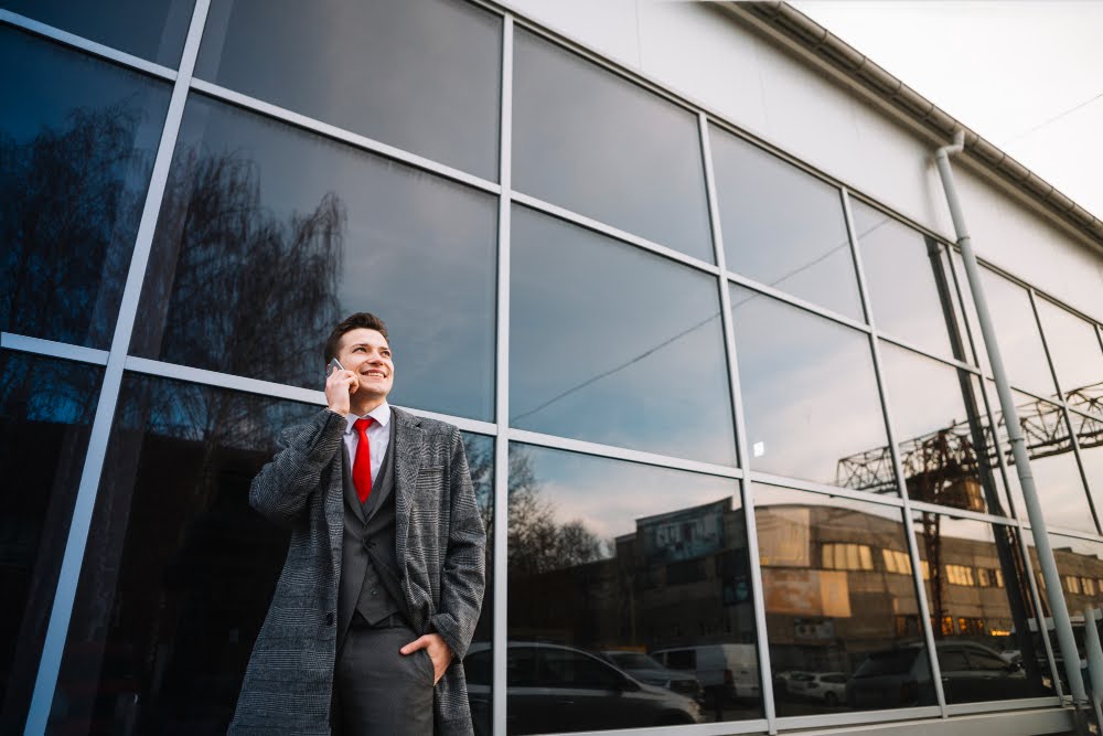 A man standing in front of commercial windows covered with security film.
