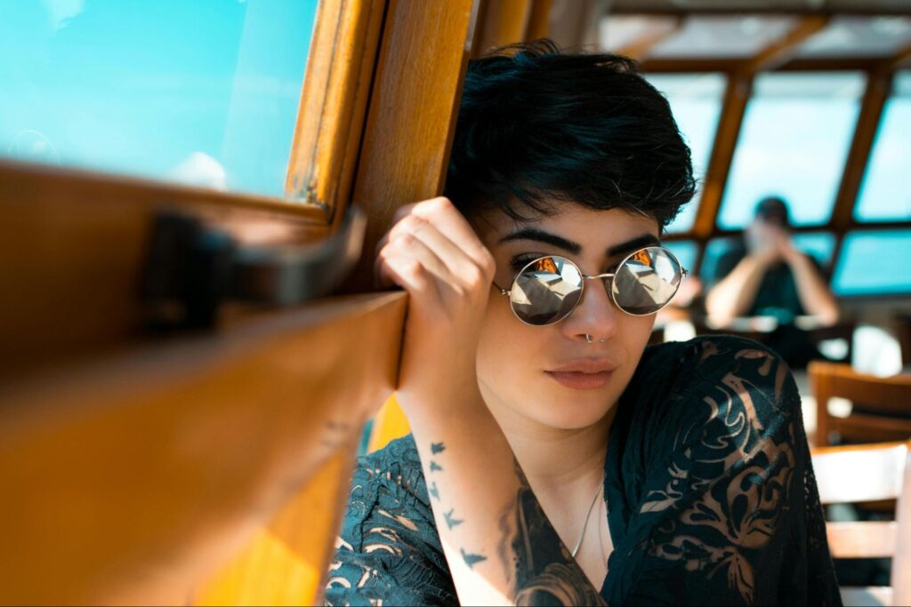 Woman Sitting Next to Window with Sunglasses