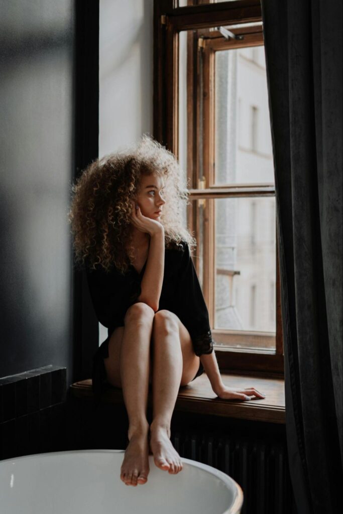 Woman Sitting on Bathroom Windowsill