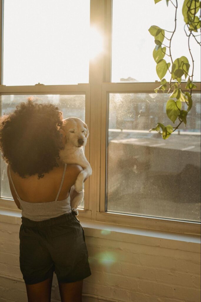 Woman Standing in Window with Dog