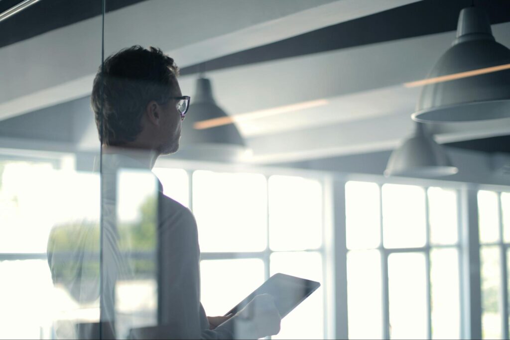 Man Standing Near Office Windows
