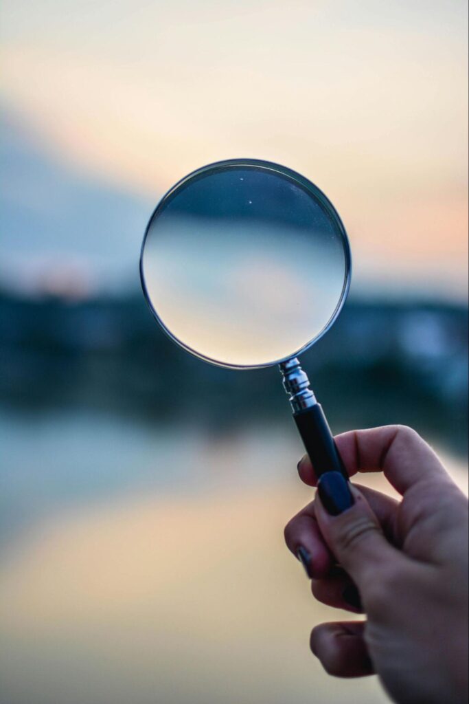 Person Holding Magnifying Glass