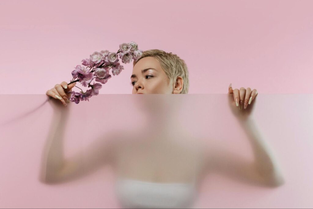Woman with Flowers Looking Over Frosted Glass