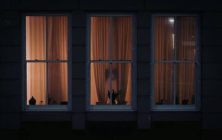 Exterior view of a house with window film applied for nighttime privacy.