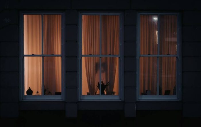 Exterior view of a house with window film applied for nighttime privacy.