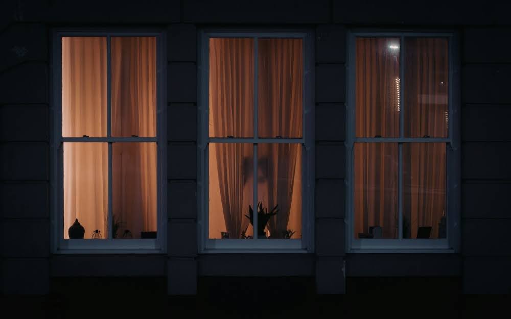Exterior view of a house with window film applied for nighttime privacy.